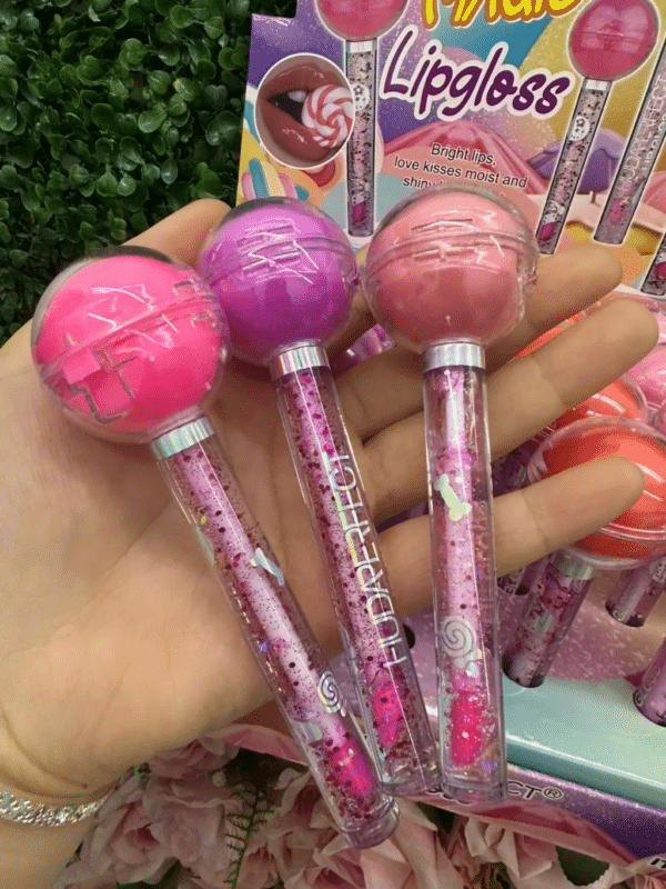 O Lip Gloss Lip Balm Pirulito - Huda Perfect combina brilho intenso, hidratação profunda e um sabor irresistível de pirulito! Com uma fórmula enriquecida com manteiga de karité, óleo de jojoba e vitamina E